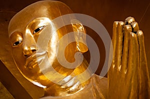 Close-up of a praying golden buddha