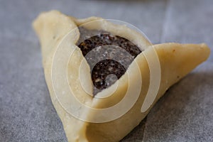 Close up of a prebaked `Haman pocket`, also known as Hamantashen, an Ashkenazi Jewish triangular filled-pocket cookie, usually ass