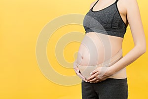 Close up of pregnancy bandage dressed on pregnant woman for reducing backpain at yellow background with copy space. Orthopedic