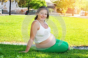 Close up of pregnant belly in nature in a city park