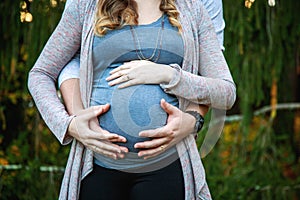 Close up of pregnant couple with hands on belly