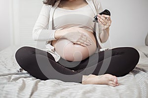 Close up of Pregnant woman applying cream at her belly