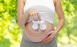 Close up of pregnant woman with baby bootees