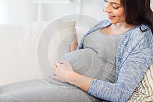 Close up of pregnant woman drinking tea at home