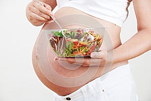 Close Up Of Pregnant Woman Eating Healthy Salad