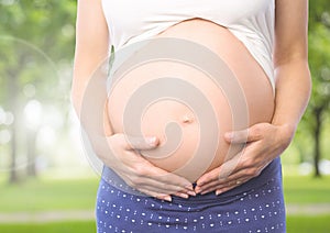 Close-up of pregnant woman holding her belly