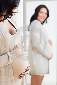 Close up of pregnant woman looking to mirror
