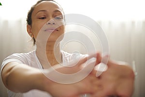 Close-up pregnant woman outstretching hands forward to camera, exercising indoor for healthy pregnancy, easy childbirth