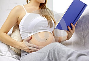 Close up of pregnant woman reading book at home