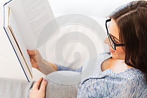 Close up of pregnant woman reading book at home