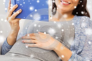 Close up of pregnant woman reading book at home