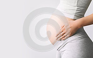 Close-up pregnant woman`s belly on white background