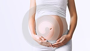 Close-up pregnant woman`s belly on white background