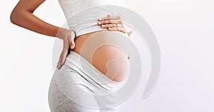 Close-up pregnant woman`s belly on white background