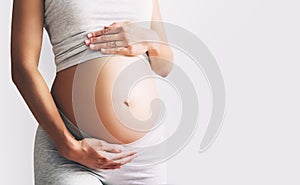 Close-up pregnant woman`s belly on white background