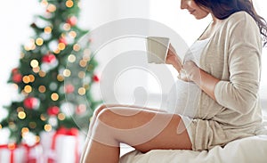 Close up of pregnant woman with tea cup at home