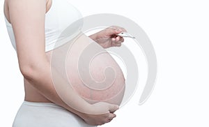 Close up pregnant woman with a thermometer in hand isolate on white background