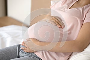 Close up of pregnant woman touch big baby bump