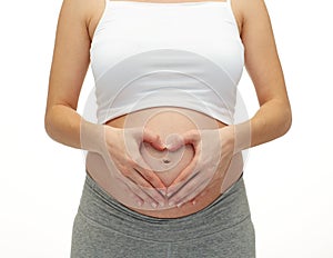 Close up of pregnant woman touching her bare tummy