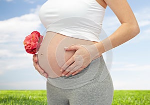 Close up of pregnant woman touching her bare tummy