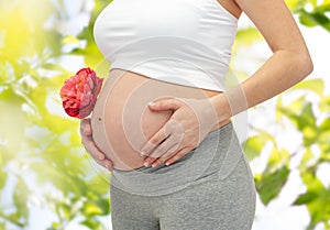 Close up of pregnant woman touching her bare tummy