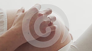 Close-up of pregnant woman touching her belly. Pregnancy, motherhood, and expectation concept