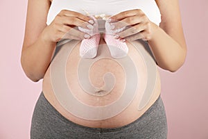 Close up of pregnant woman wearing supportive seamless maternity bra and maxi bottoms and grey yoga pants. Child expectancy