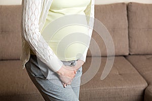 Close up of pregnant women urine urgency at home. pregnant urinary incontinence concept