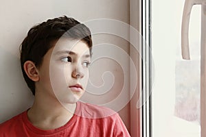 Close up preteen boy portrait look at the window