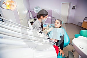 Close-up of pretty little girl opening his mouth wide during treating her teeth by the dentist