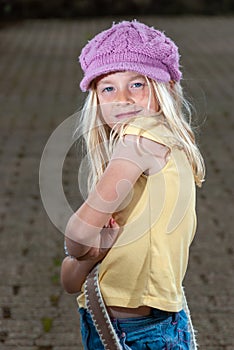 Close up of pretty young blonde hippie girl in pink hat and attitude