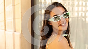 Close-up of pretty young caucasian girl looking and smiling at camera with good mood outdoor.