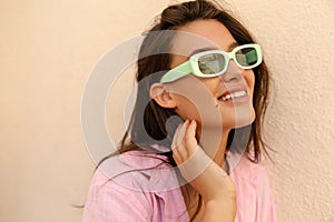 Close-up of pretty young caucasian model looking at distance smiling spends free time outdoor.