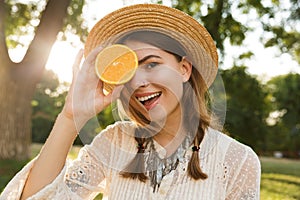 Close up of pretty young girl in summer hat spending time at the park,