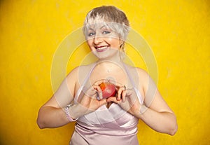 Close up pretty young woman holding an apple she`s about to eat