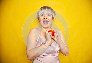Close up pretty young woman holding an apple she`s about to eat