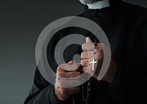 Close up of a priest holding rosary