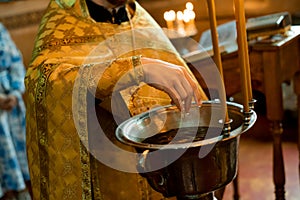 Close-up of a priest`s hands with a basin of water