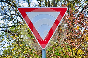 Close up of a priority sign in Germany in front of trees