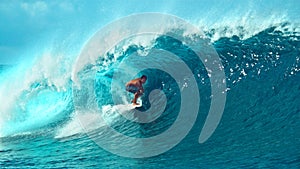 CLOSE UP: Pro surfer surfs a big barrel wave in popular surf spot in Tahiti.