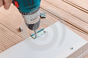 Close-up of the process of installation a furniture with electric screwdriver