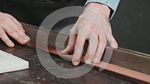 Close up of process of manufacturing a leather belt by a tanner. Workshop tanner.