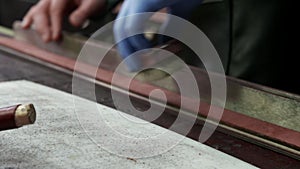 Close up of process of manufacturing a leather belt by a tanner. Workshop tanner.