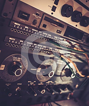 Close-up professional audio equipment with sliders and knobs at recording studio.