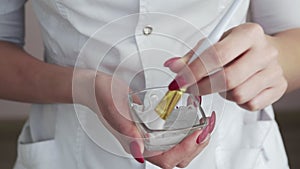 Close up of Professional beautician makes a white clay mask