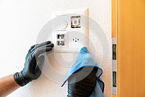 Close up of a professional cleaner cleaning a modern light switch and dimmer and socket