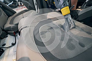 Close-up professional dry cleaning of car seat. Washing vacuum cleaner