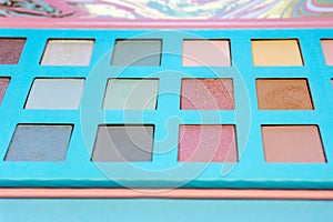 Close-up of professional eye shadows on a blue background. Fashion and beauty concept.