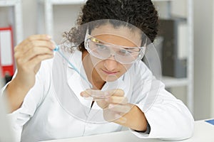 close-up professional female scientist in protective eyeglasses