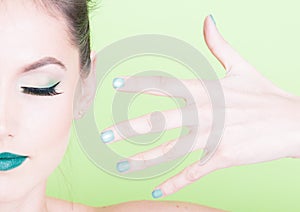 Close-up of professional green make-up with matching nails